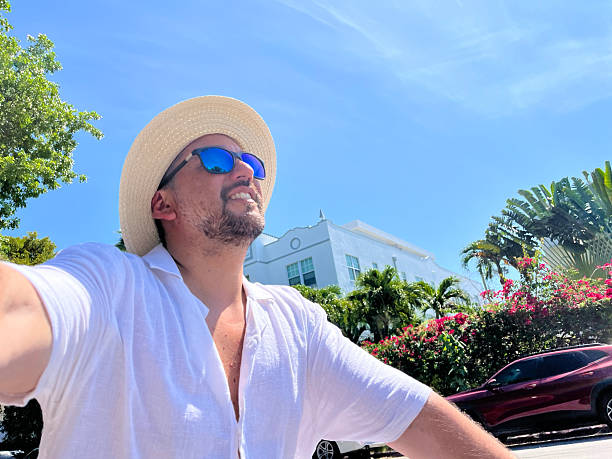Tourist riding a bicycle and taking a selfie in Miami Beach