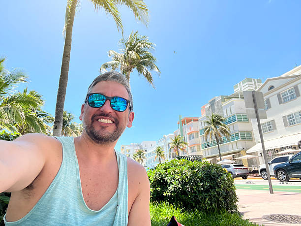 istock Tourist taking a selfie in Miami Beach, Florida, under palm trees 2219967749