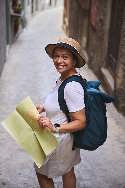 istock Woman Exploring Medieval City Streets With a Map and Backpack 2219968931