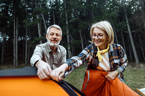 istock Mature couple setting up tent together in forest 2219968961