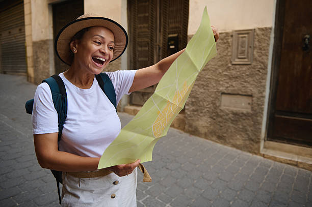 A cheerful woman in summer attire enjoys exploring a historic town, navigating quaint narrow streets with her map in hand, embracing the joy of discovery and adventure.