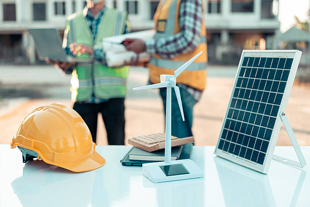 istock Two engineers work on wind turbine model components and discuss renewable energy sources of the solution with the computer. Wind turbine solar panel model to develop sustainable energy projects. 2219969642