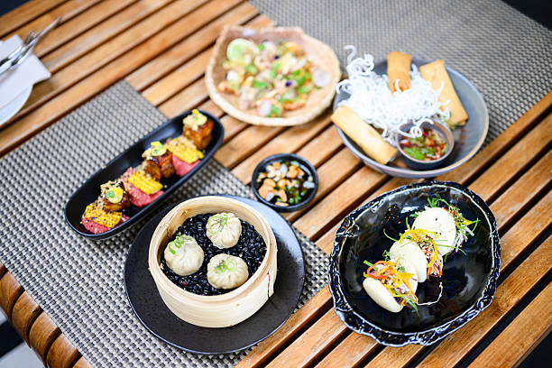 istock Fine dining scene with assorted Asian appetisers including dumplings, spring rolls and pork belly on wooden table 2219971652