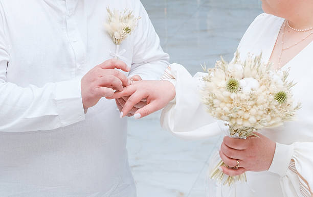 istock Couple exchanges wedding rings during intimate ceremony on a calm day 2219981094