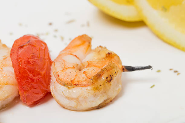 Grilled shrimp skewers with tomatoes. As a whole background