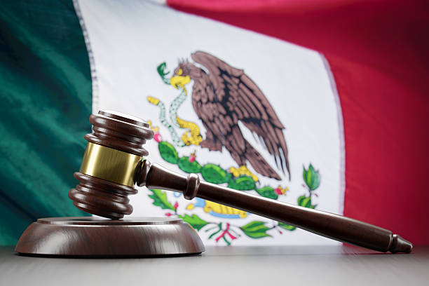 istock Wooden Gavel Resting on Table In Front of Mexican Flag. 2219994870