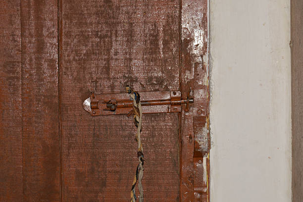 istock Rustic Iron Door Bolt on Weathered Wooden Door with Wire 2219997370
