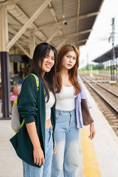 istock Two young woman at train station together 2219998365