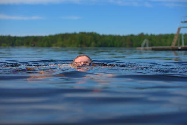 Person emerging from water in scenic lake.