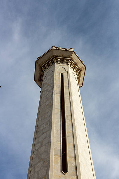 istock A tall, octagonal tower reaches up towards a cloudy sky. 2219999890