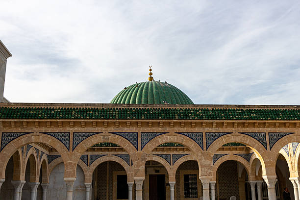 istock A building with a green dome sits behind a series of arched columns. 2219999925