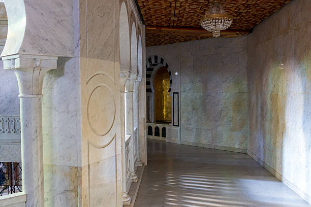 A long corridor features intricate tile work and arches, leading to a sunlit window in the distance at the Habiba Burgiba mausoleum - Monastir - Tunisia - Africa