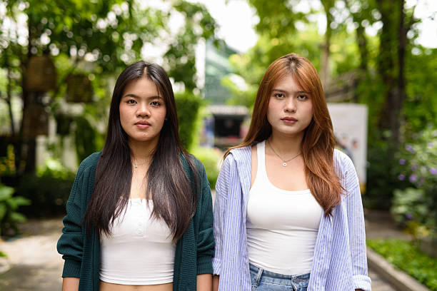 Portrait of two young Asian woman together in park during summer