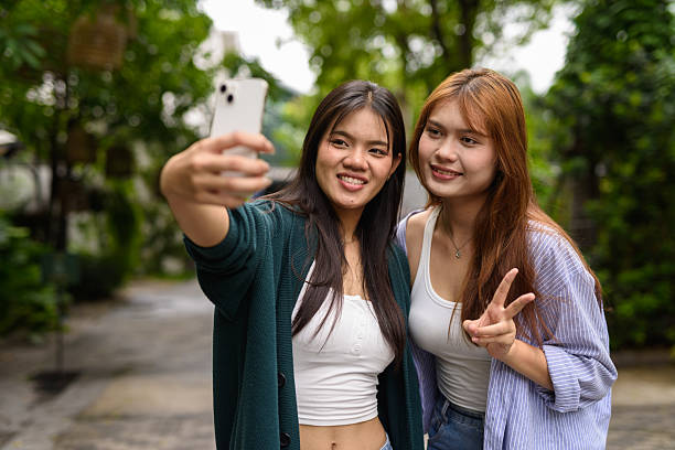 istock Two young woman together in park during summer 2220000463
