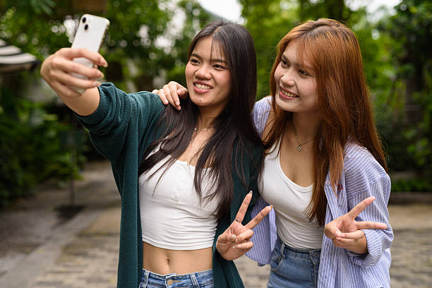 istock Two young woman together in park during summer 2220000875