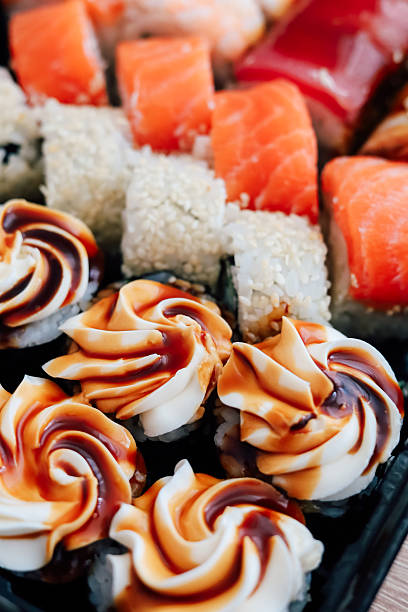 Fresh sushi and dessert selection presented on a black platter at a casual dining setting