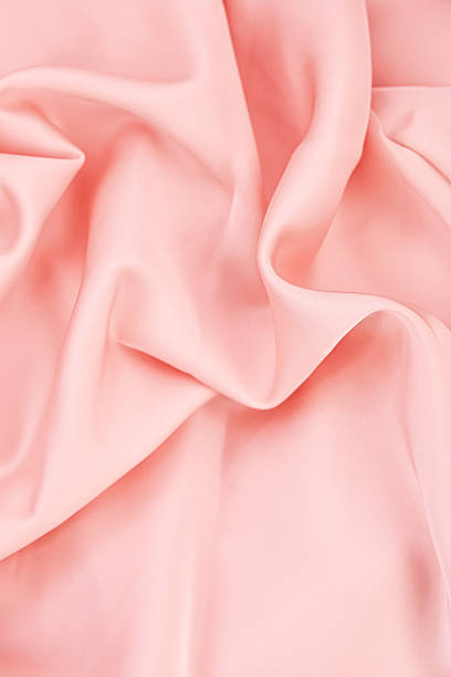 istock Soft pink fabric creating gentle folds and waves under bright lighting in a textile studio 2220001797