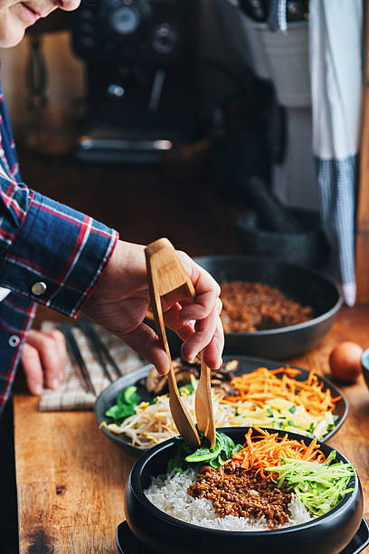 istock Preparing Bibimbap Korean Rice Dish in Domestic Kitchen 2220004289