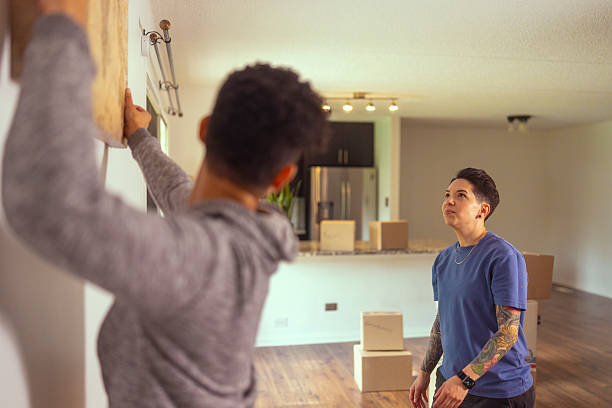 istock Lesbian couple unpacking and decorating their new apartment 2220004483