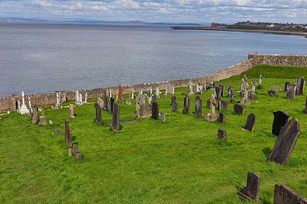 istock A grassy graveyard sits near the ocean under a cloudy sky. 2220005860
