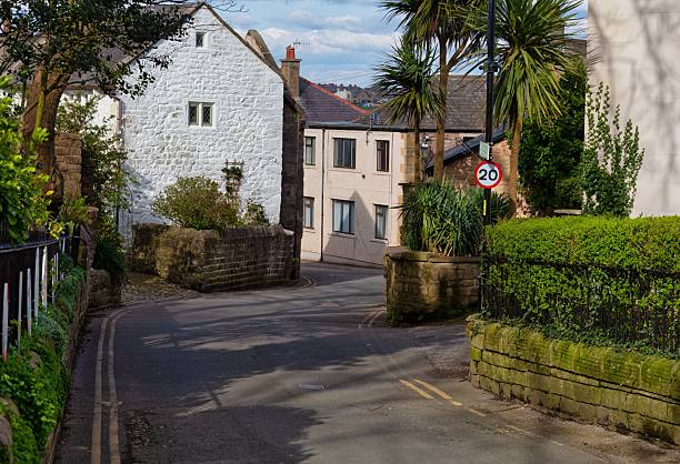 istock A quiet street scene shows white buildings and lush greenery under a partly cloudy sky. 2220006137