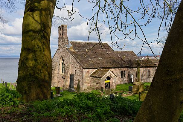 istock A building with a tiled roof is partially obscured by trees and branches. 2220006368