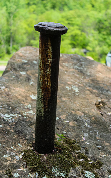 istock a large weathered metal rod tool embedded in a huge quarry boulder. 2220011357