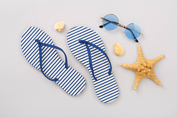 istock Striped blue flip flops with accessories on color background, top view 2220012402