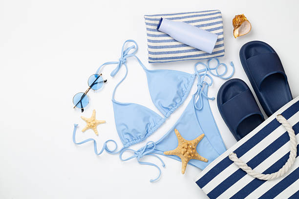 istock Blue bikini with beach accessories on color background, top view 2220012407
