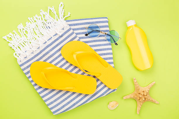istock Beach towel with summer accessories on color background, top view 2220012410
