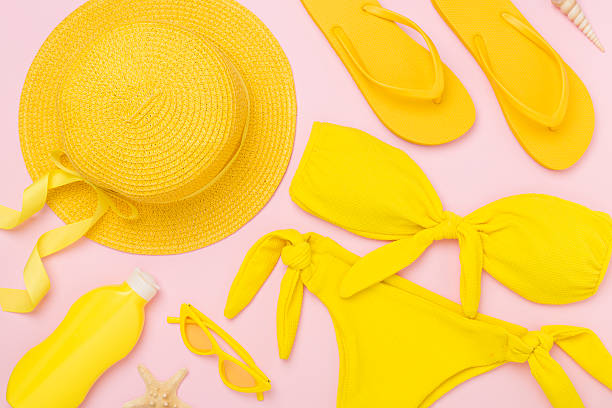 Flat lay with yellow summer outfit on color background. Vacation concept