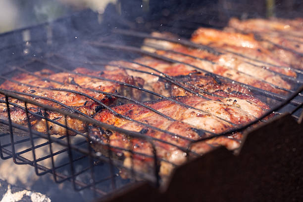 istock Pork steaks grilling on a barbecue with smoke 2220016104