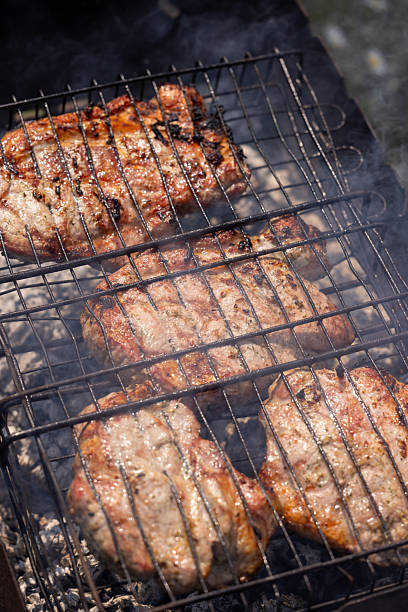 istock Pork steaks grilling on a barbecue grill over hot coals 2220016267
