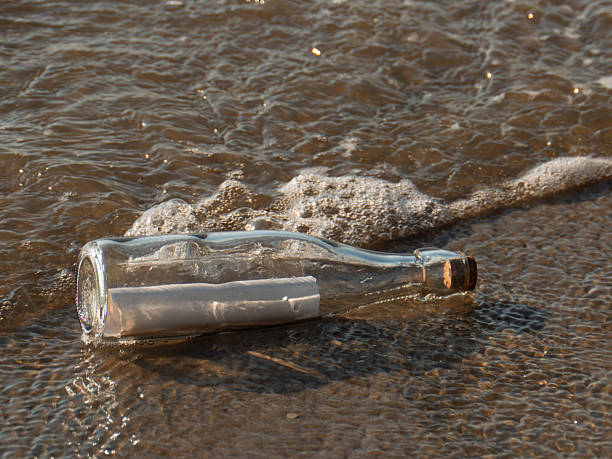 istock Message in a Bottle on a Sandy Shoreline 2220017280