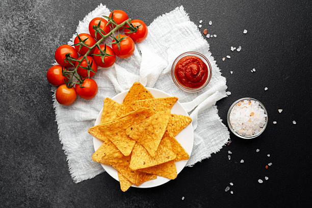 istock Nachos with fresh tomatoes, salsa and salt on white cloth over dark background 2220025274
