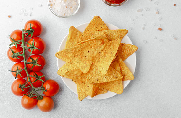 istock Crispy nachos with tomatoes, salsa and salt on white background 2220025289