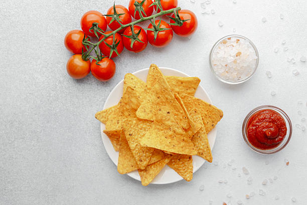 istock Crispy nachos with tomatoes, salsa and salt on white background 2220025291