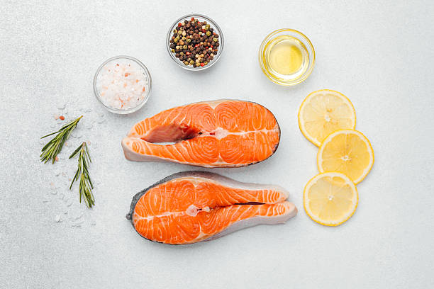 istock Fresh salmon fillets prepared with herbs and lemon on a kitchen countertop 2220025375