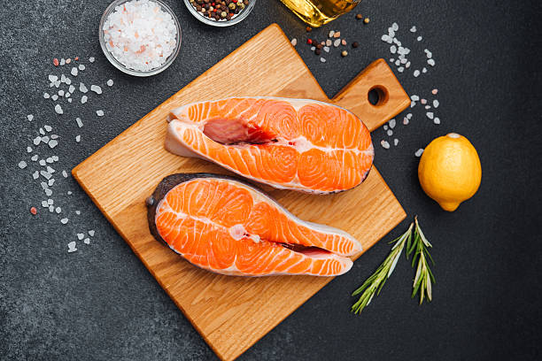 istock Fresh salmon fillets prepared with herbs and spices on a cutting board 2220025382