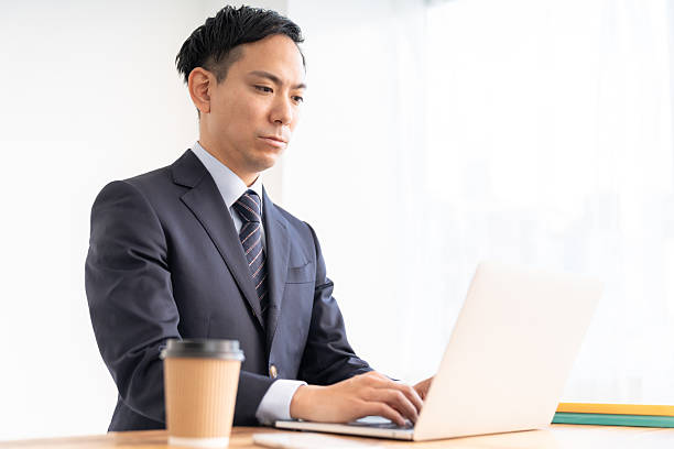 istock attractive asian businessman using laptop 2220033358