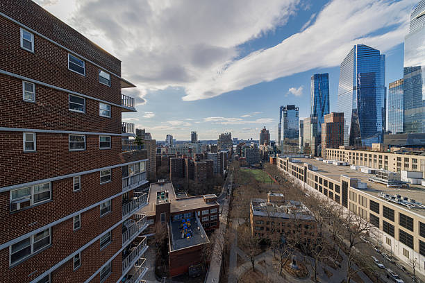 istock Residential meets luxury development. Brick apartment building contrasts with gleaming skyscrapers of Hudson Yards in New York City. 2220039045