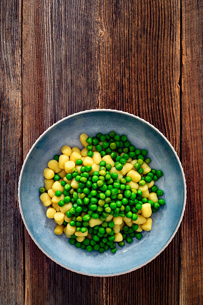 istock Gnocchi with green peas on wooden table 2220043927
