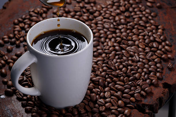 istock black coffee in white mug with surrounded by roasted coffee beans on dark red wood table 2220045222