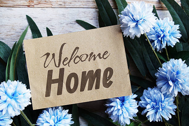 istock Welcome Home text message with flower decoration on wooden background 2220045435