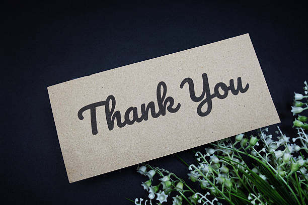 istock Thank you text message with flower decoration on black background 2220045446