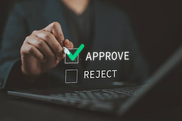 istock Businessman with pen ticking the correct mark to approve document or project concept. Document management, examination, survey, tick for technology certification. Approved, accepted, pass review. 2220047826