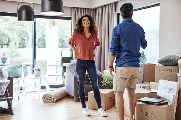 istock Couple Joyfully Unpacking in Their New Home Surrounded by Moving Boxes 2220064745