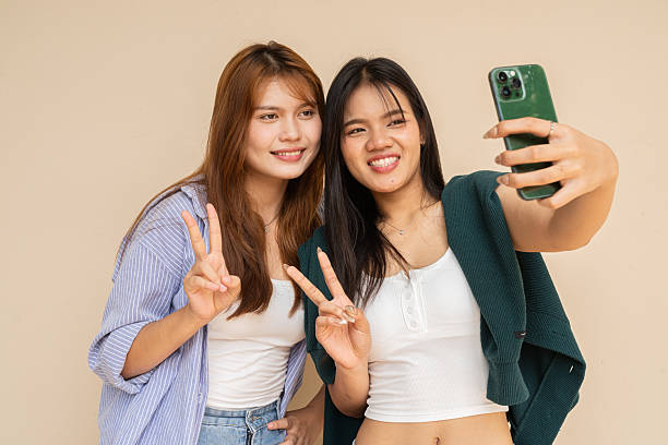 istock Portrait of two young women against plain wall 2220070691