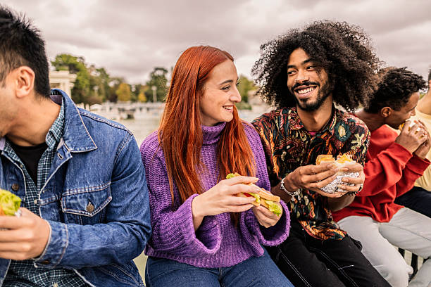 istock Young people eating sandwiches outdoors in urban setting 2220072862