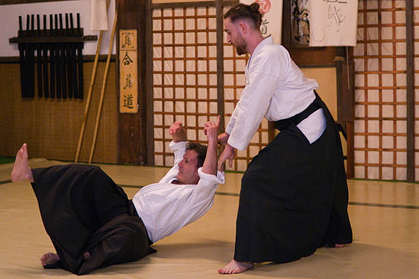 istock Aikido master performing a throw in traditional dojo 2220073157